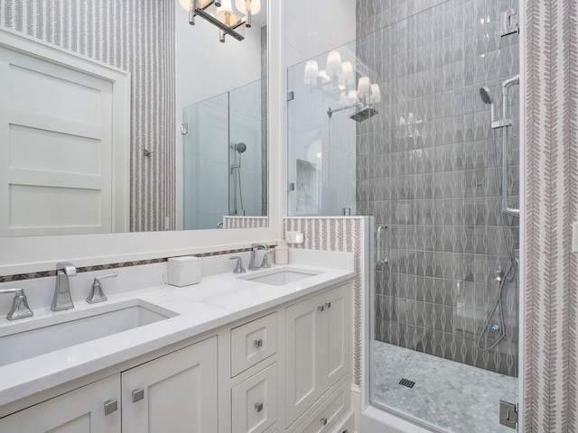 full bathroom featuring a sink, double vanity, and a shower stall