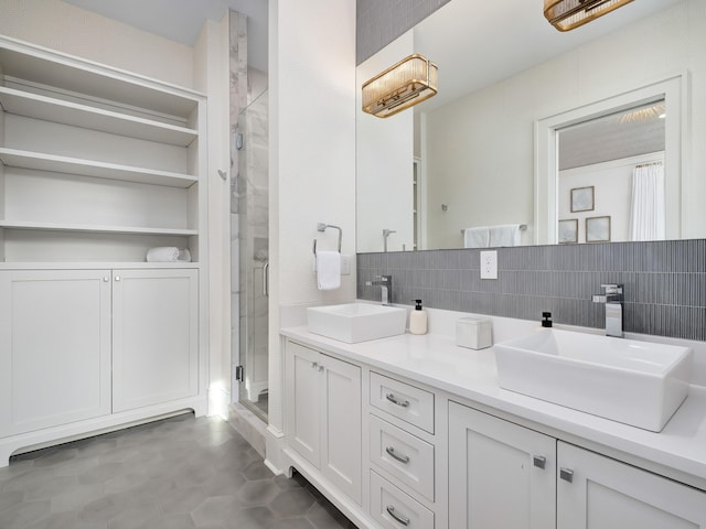 bathroom with backsplash, a shower stall, double vanity, and a sink