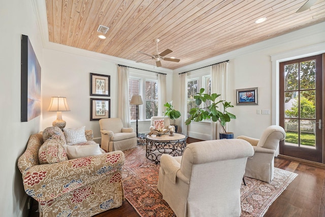 living area with wooden ceiling, a healthy amount of sunlight, wood finished floors, and ornamental molding