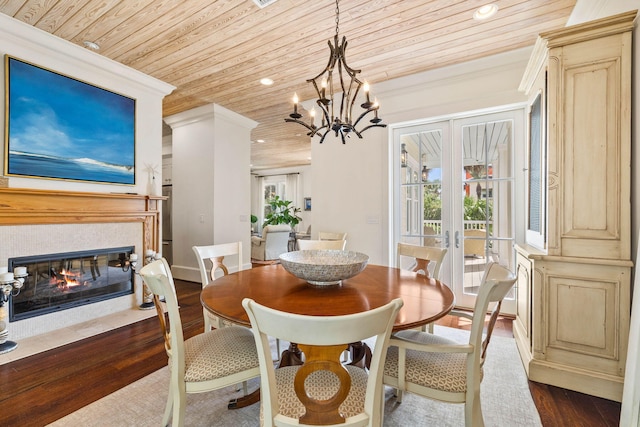 dining space with dark wood-style floors, a multi sided fireplace, french doors, and wooden ceiling