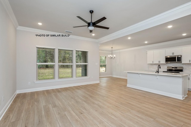 unfurnished living room featuring visible vents, light wood-style flooring, ceiling fan with notable chandelier, a sink, and crown molding