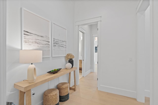 hallway featuring baseboards and light wood-type flooring