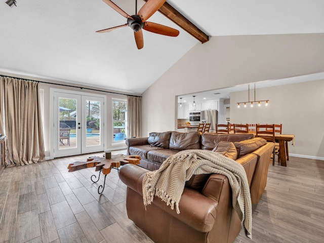 living area with a ceiling fan, high vaulted ceiling, beam ceiling, light wood-style floors, and french doors