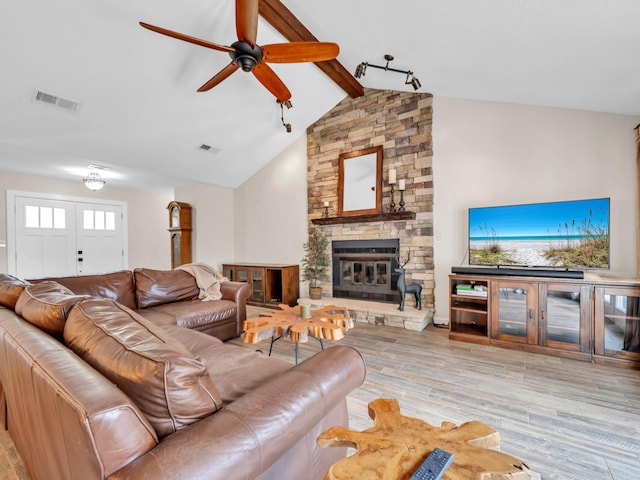 living area featuring lofted ceiling with beams, visible vents, wood finished floors, and ceiling fan