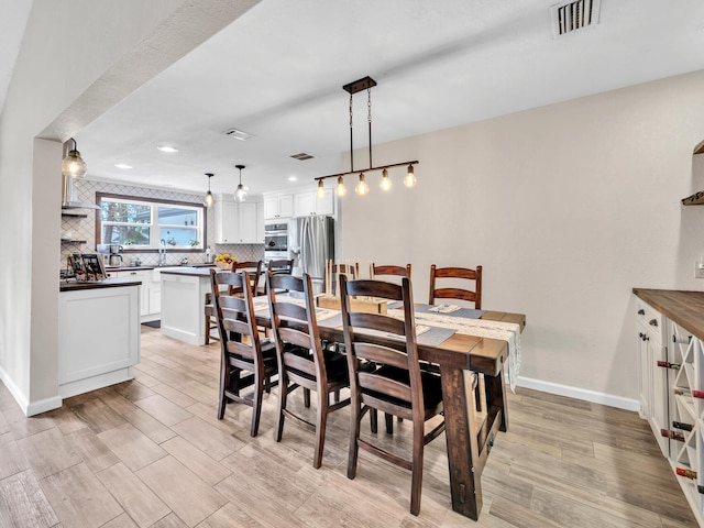 dining area with light wood-style flooring, recessed lighting, baseboards, and visible vents