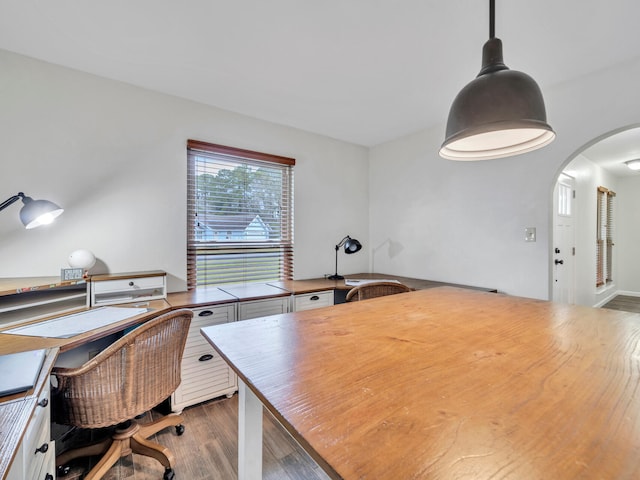 home office featuring arched walkways and wood finished floors