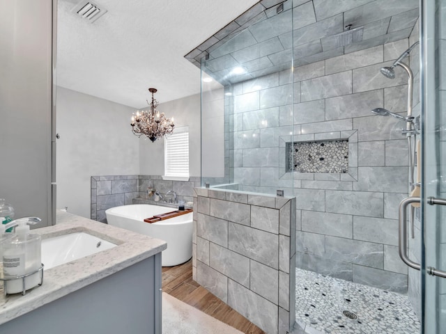 full bathroom with visible vents, a shower stall, wood finished floors, a soaking tub, and tile walls