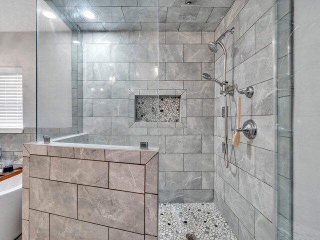 full bathroom featuring a tub to relax in and a walk in shower