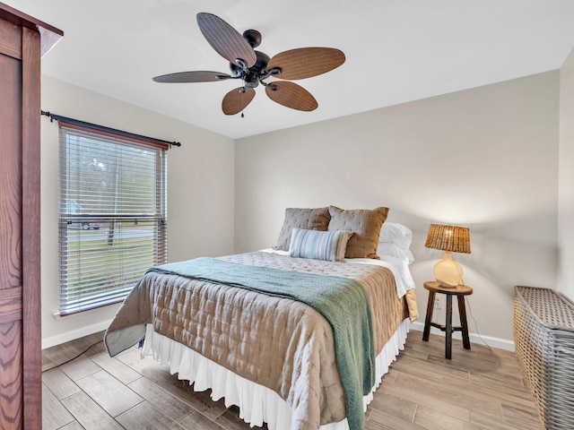 bedroom featuring multiple windows, baseboards, and wood tiled floor