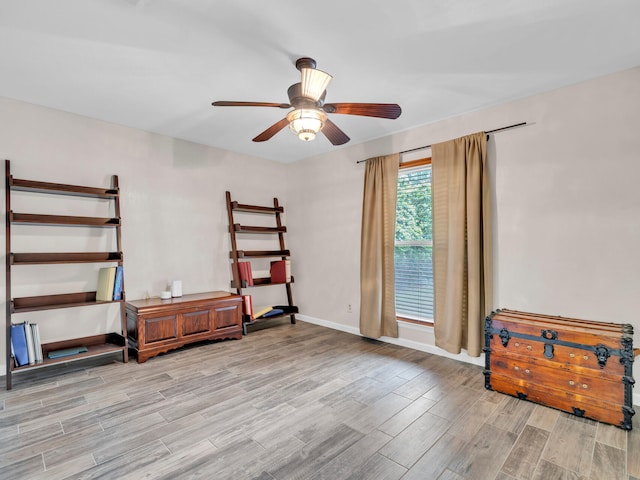 interior space featuring baseboards, wood finished floors, and a ceiling fan