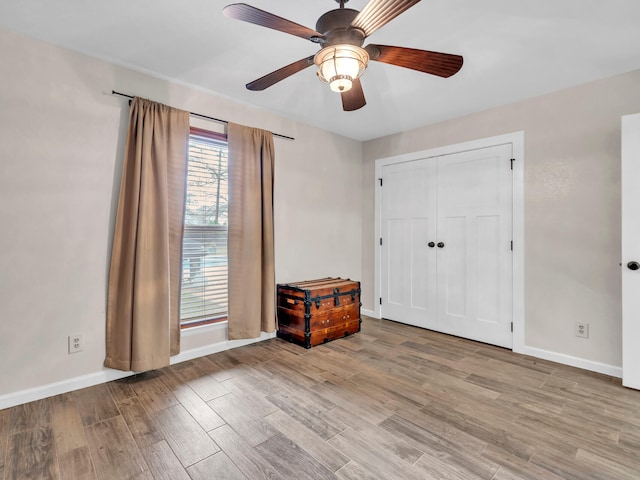 unfurnished bedroom featuring a ceiling fan, baseboards, and wood finished floors