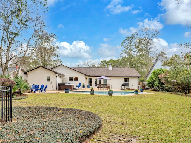 back of house featuring a patio area, a lawn, an outdoor pool, and a chimney