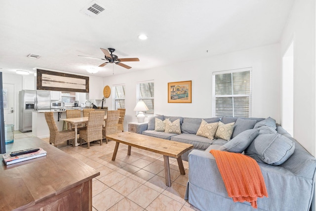 living area featuring light tile patterned floors, visible vents, ceiling fan, and recessed lighting