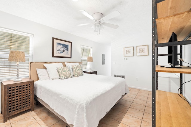 bedroom featuring electric panel, visible vents, a textured ceiling, and light tile patterned floors