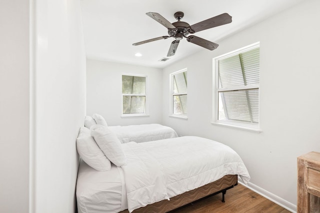 bedroom with a ceiling fan, wood finished floors, visible vents, baseboards, and recessed lighting