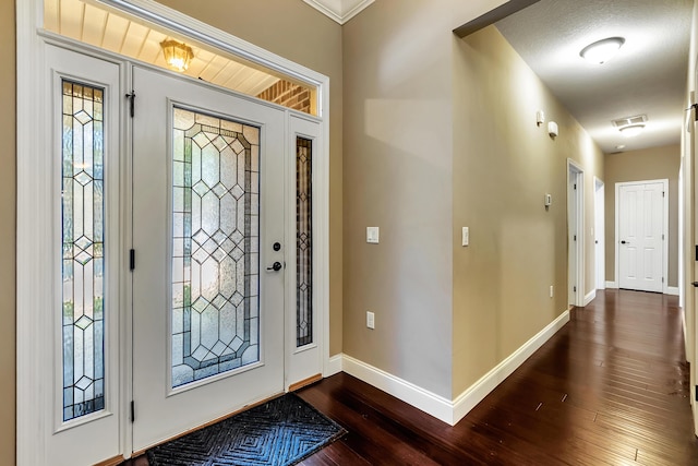 foyer entrance featuring visible vents, baseboards, and dark wood finished floors