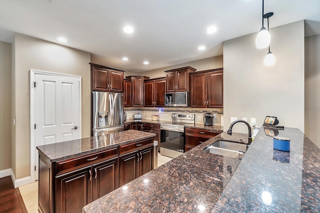 kitchen featuring a sink, dark stone countertops, backsplash, appliances with stainless steel finishes, and dark brown cabinets