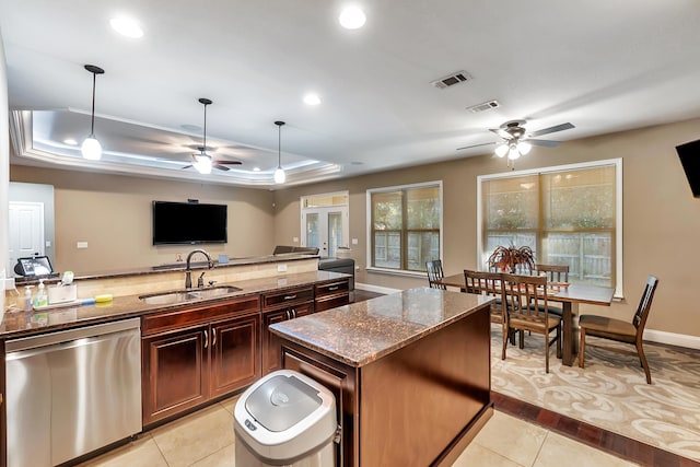 kitchen featuring a sink, a tray ceiling, stainless steel dishwasher, and visible vents