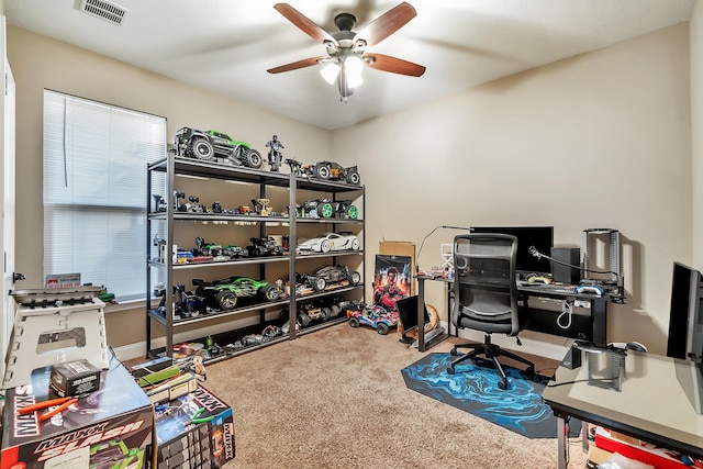 carpeted home office featuring a ceiling fan, visible vents, and baseboards