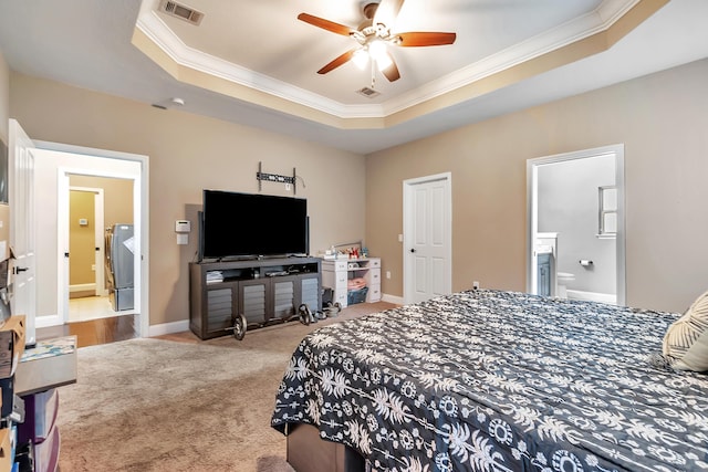 bedroom with visible vents, freestanding refrigerator, crown molding, carpet flooring, and a raised ceiling