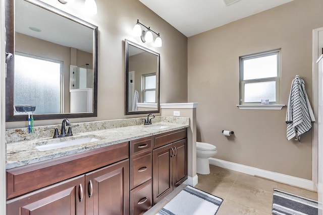 full bath with tile patterned flooring, double vanity, baseboards, and a sink