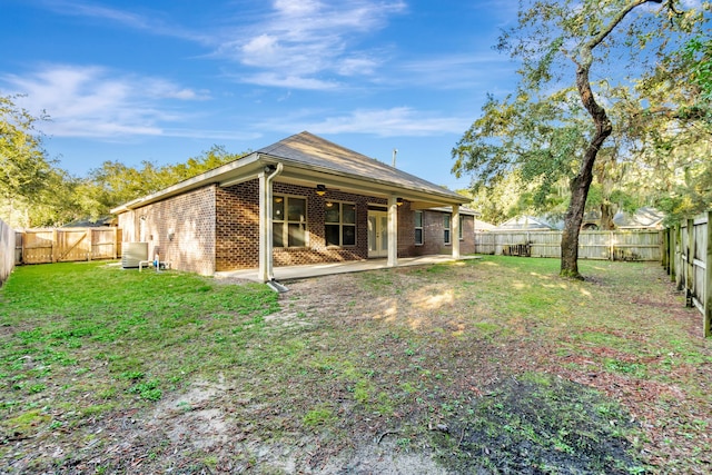 rear view of house with a patio area, a fenced backyard, brick siding, and a lawn