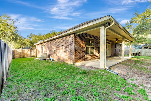 rear view of house featuring a patio area, a yard, a fenced backyard, and brick siding