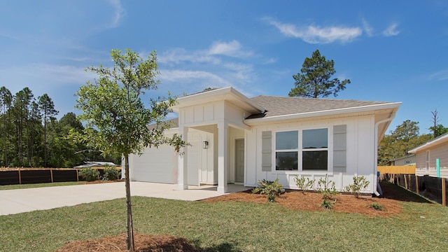 217 Eunola Ln, Freeport, FL 32439 - ranch-style house featuring a front yard, roof with shingles, concrete driveway, an attached garage, and fence