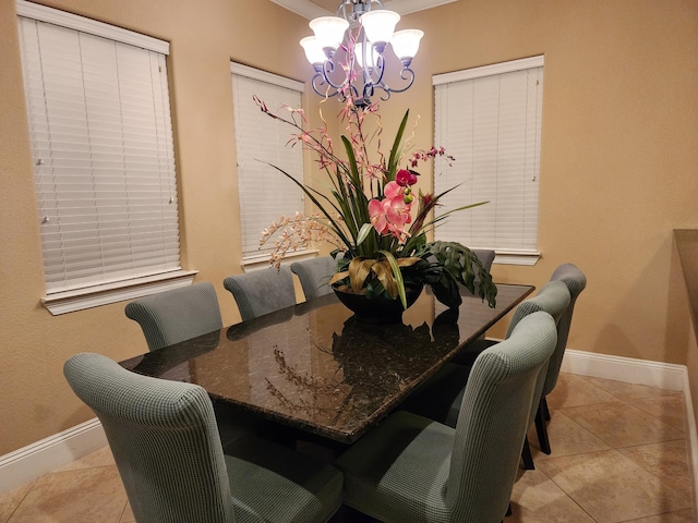 dining area featuring baseboards, a chandelier, and tile patterned flooring