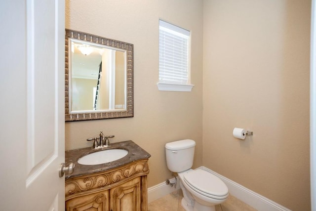 bathroom featuring vanity, toilet, and baseboards