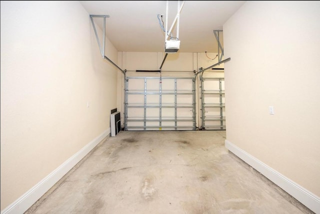 garage with a garage door opener and baseboards