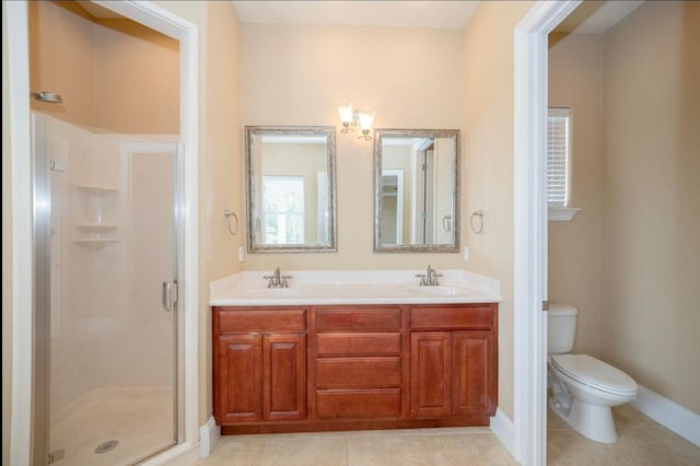 full bath featuring toilet, double vanity, a stall shower, tile patterned floors, and a sink