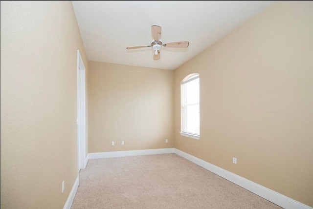 unfurnished room with light colored carpet, baseboards, and ceiling fan