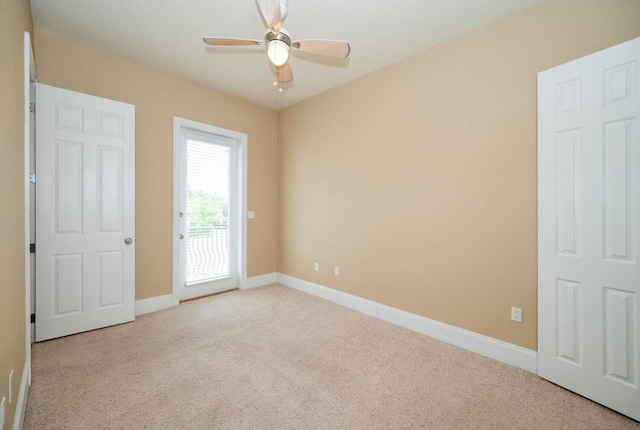 empty room featuring a ceiling fan, baseboards, and carpet floors