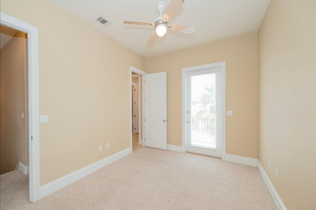 unfurnished room featuring visible vents, light colored carpet, a ceiling fan, and baseboards