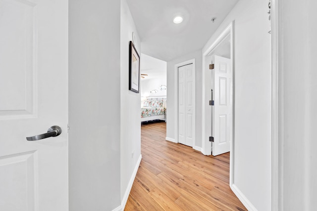 hall featuring light wood finished floors and baseboards