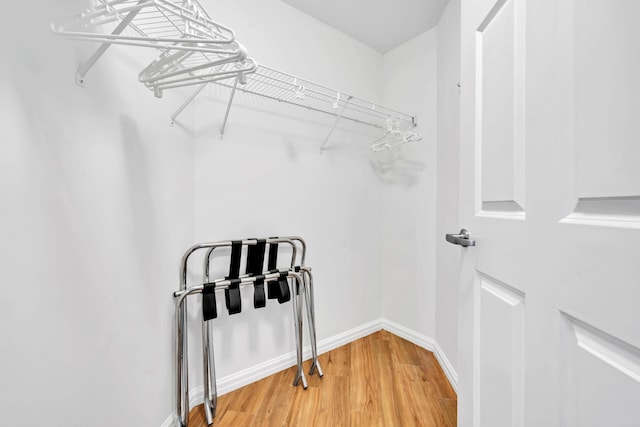 walk in closet with light wood-style floors