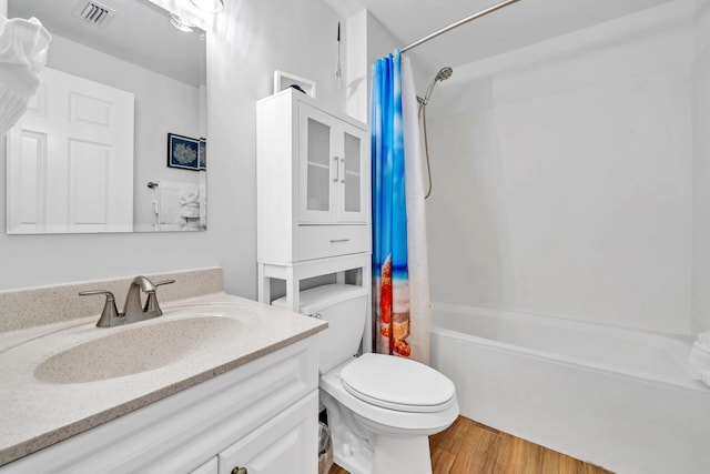 bathroom featuring visible vents, shower / tub combo with curtain, toilet, wood finished floors, and vanity