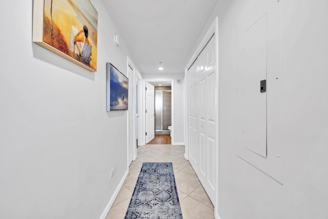 corridor featuring light tile patterned floors, recessed lighting, and baseboards