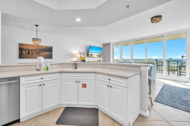 kitchen with stainless steel dishwasher, light countertops, and light tile patterned floors