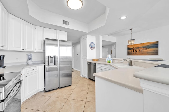 kitchen with visible vents, a tray ceiling, light tile patterned floors, appliances with stainless steel finishes, and white cabinets