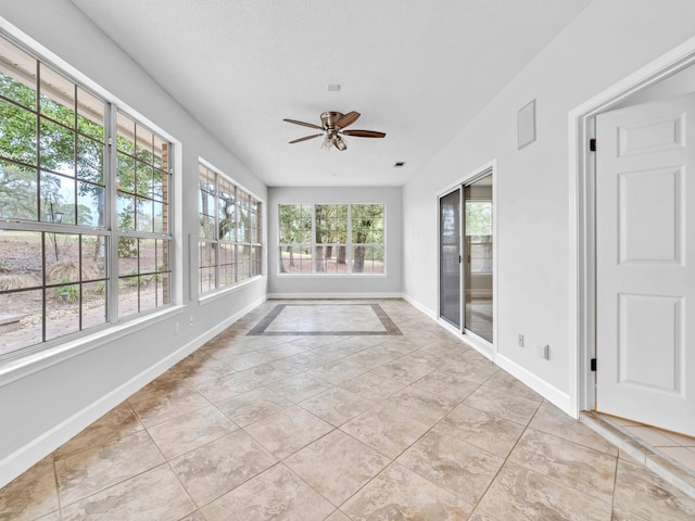 unfurnished sunroom featuring a ceiling fan