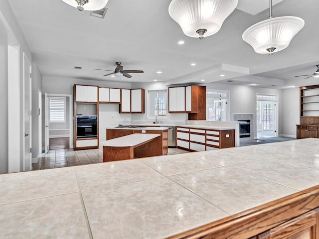 kitchen with black oven, a center island, recessed lighting, dishwasher, and ceiling fan