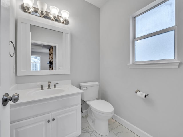 bathroom with baseboards, toilet, marble finish floor, and plenty of natural light