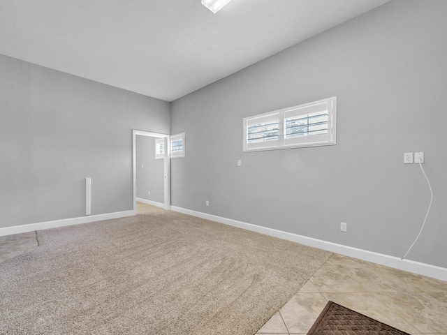 empty room featuring light carpet and baseboards