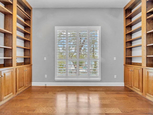 interior space featuring baseboards and light wood finished floors