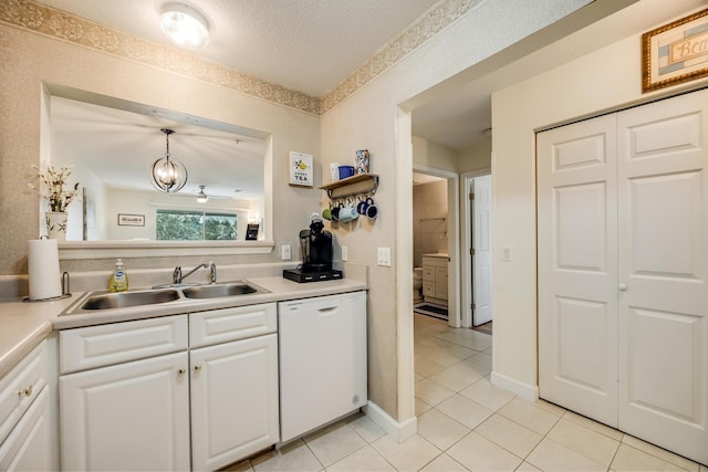 kitchen with light countertops, white cabinets, white dishwasher, and a sink