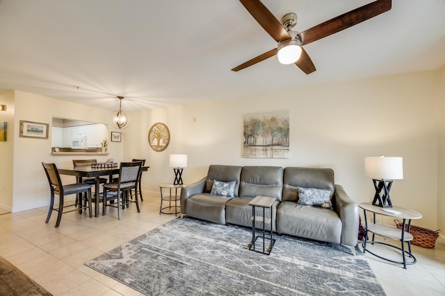 tiled living area with baseboards and ceiling fan