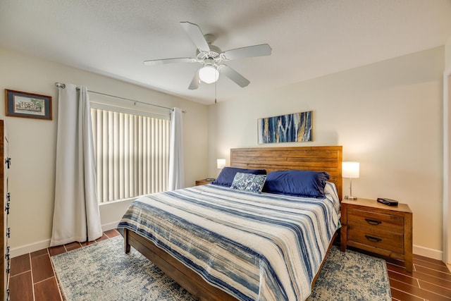 bedroom featuring baseboards, a ceiling fan, and wood tiled floor