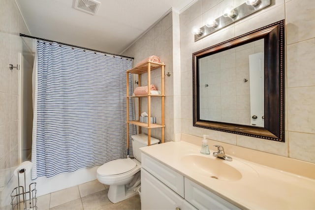 bathroom featuring visible vents, toilet, tile walls, tile patterned flooring, and vanity